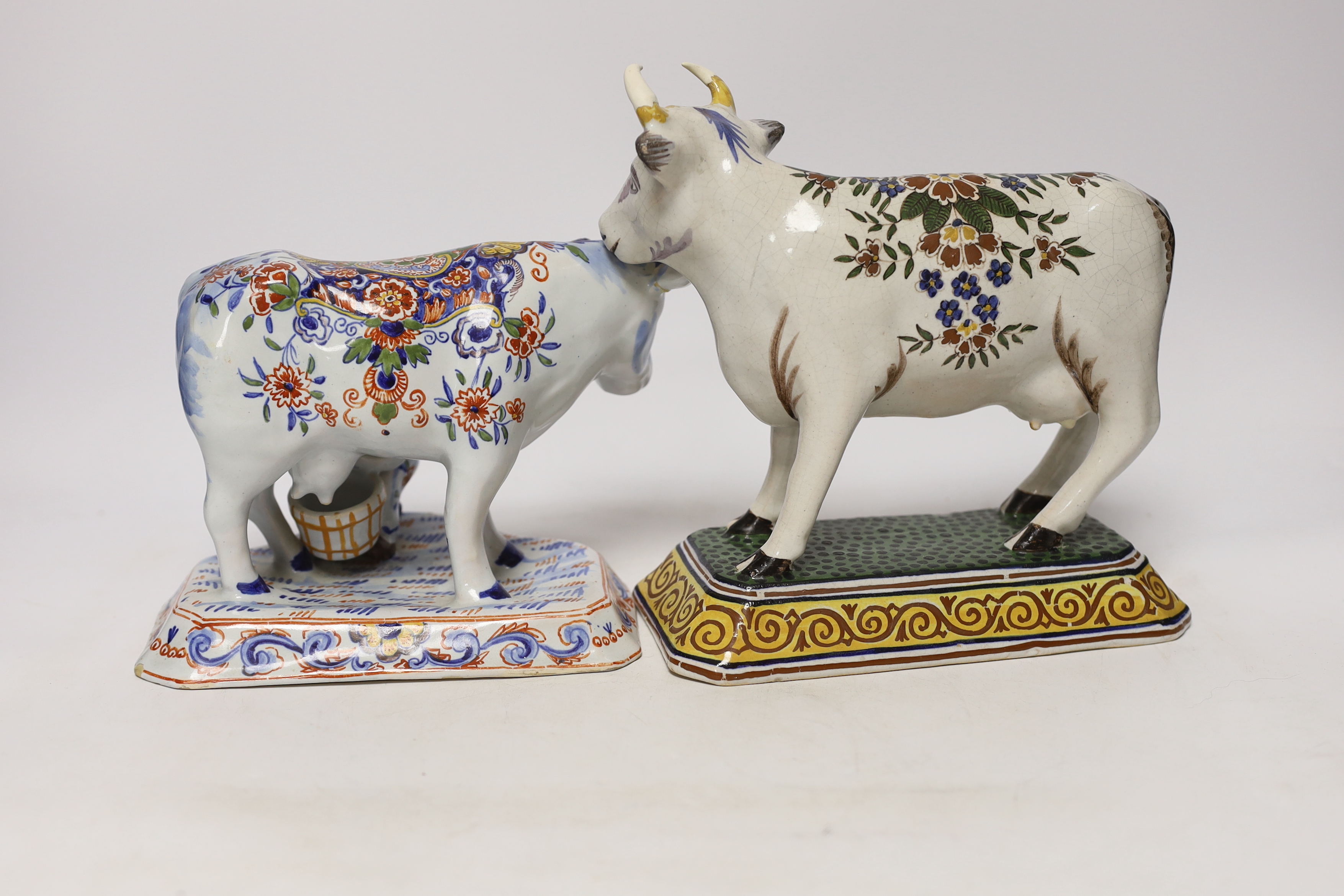 Two 19th century Delft models of cows, one with milkmaid, tallest 22cm